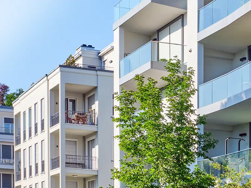 Seher Startbild Karriere mobil: urbane Wohnbebauung mit Balkonen und Bäumen.